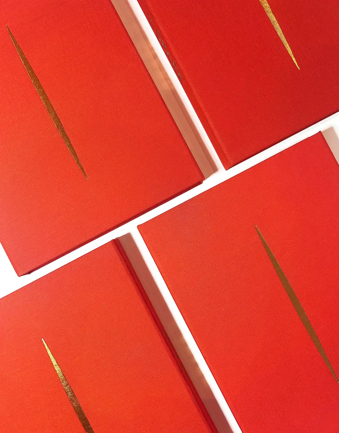 Four copies of The Spark: Portraits of Purpose in red cloth with a single gold foil stroke